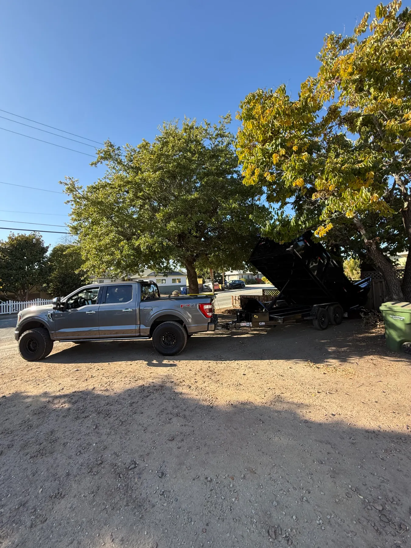 Pickup truck and dump trailer parked on a job site